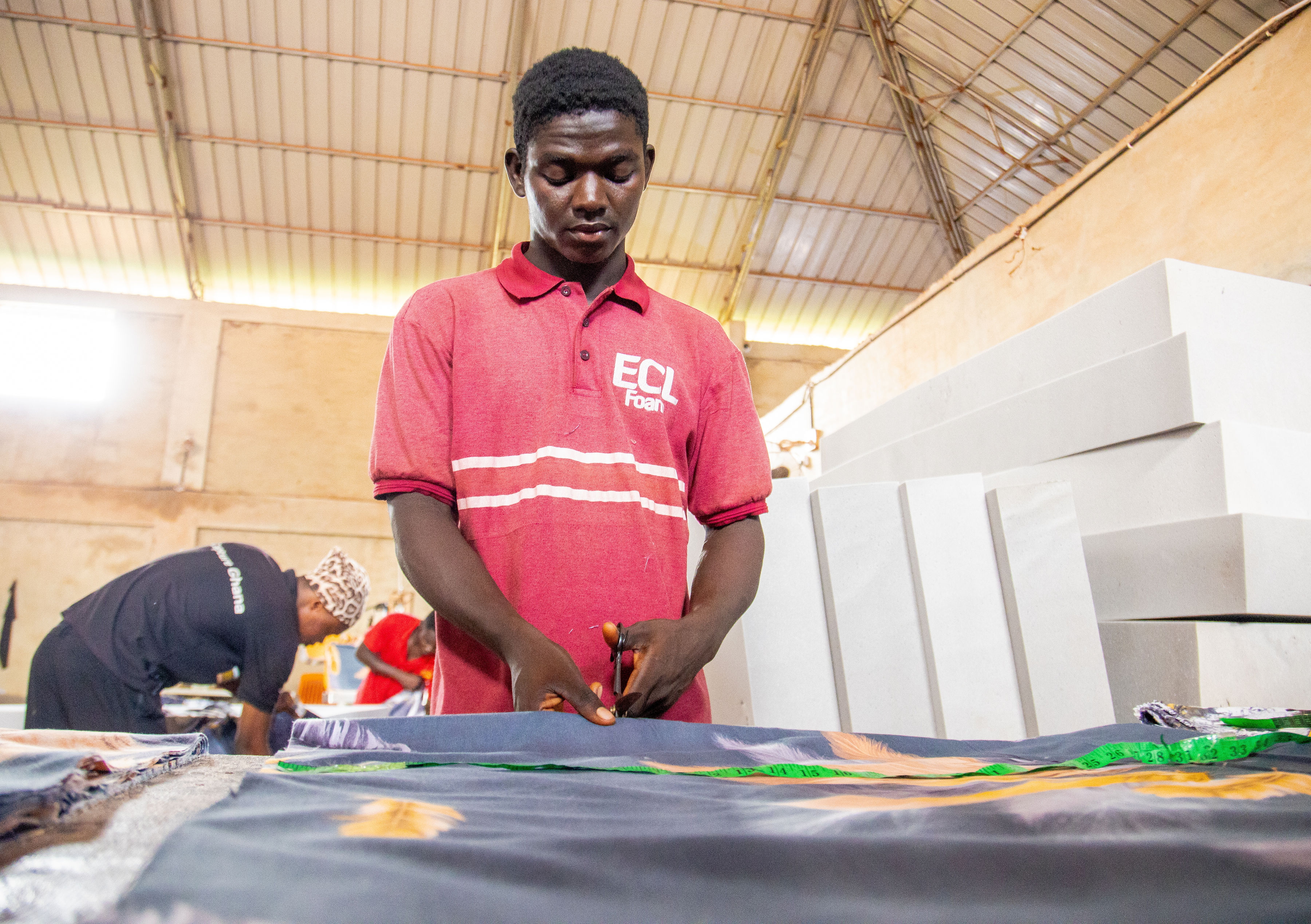 Extra Comfort staff member cutting mattress fabric inside the production area