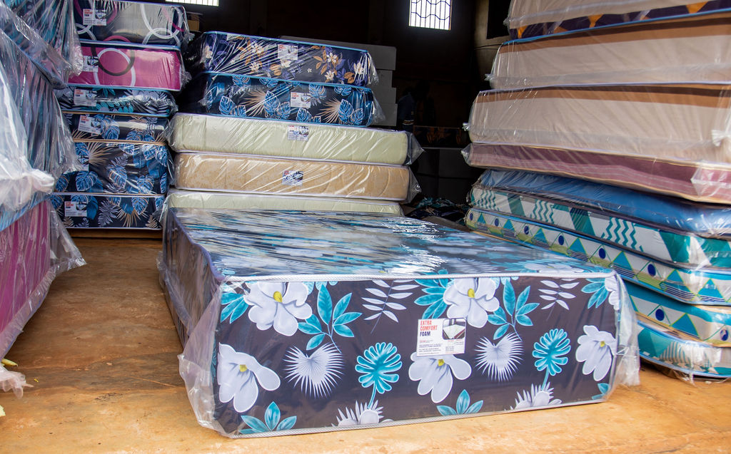 Mattress display on the showroom floor with surrounding stock