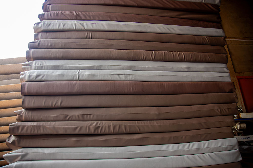 Stacked utility mattresses in neutral brown and cream finishes