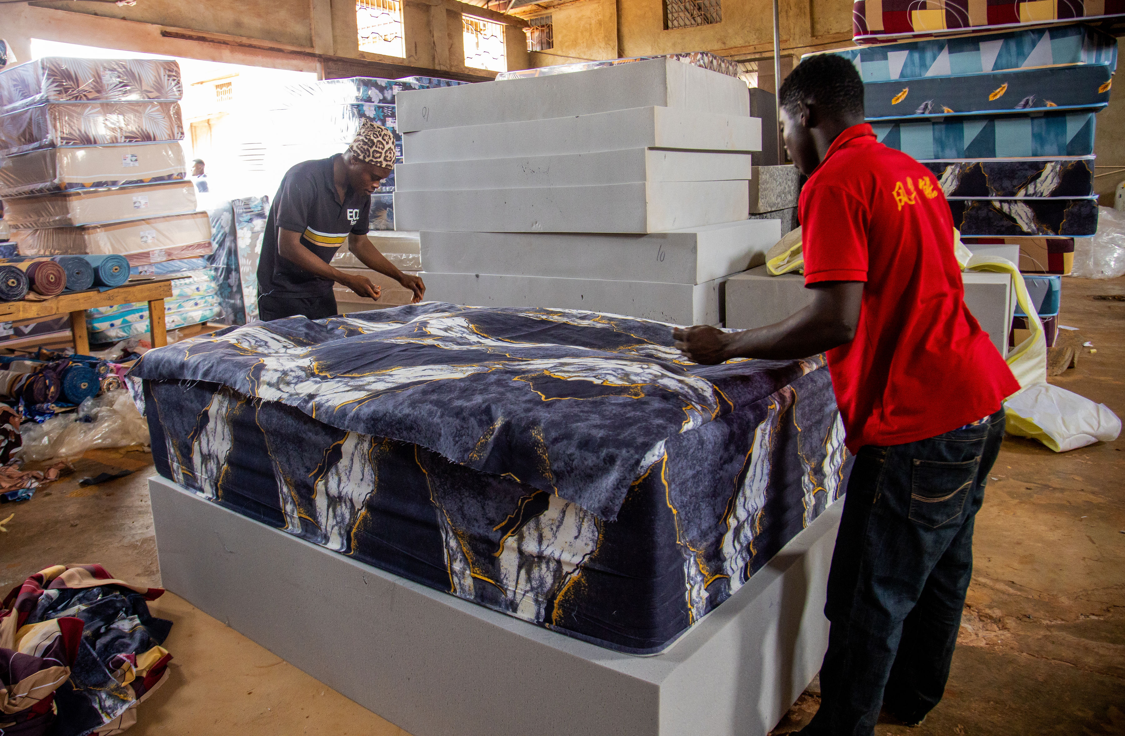 Factory staff preparing a finished mattress in the workshop